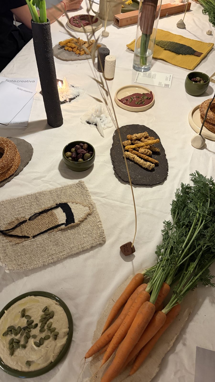 Platos de cerámica con comida, zanahorias y textiles sobre la mesa