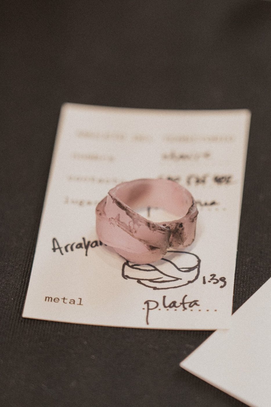 Anillo en cera rosa sobre su ficha