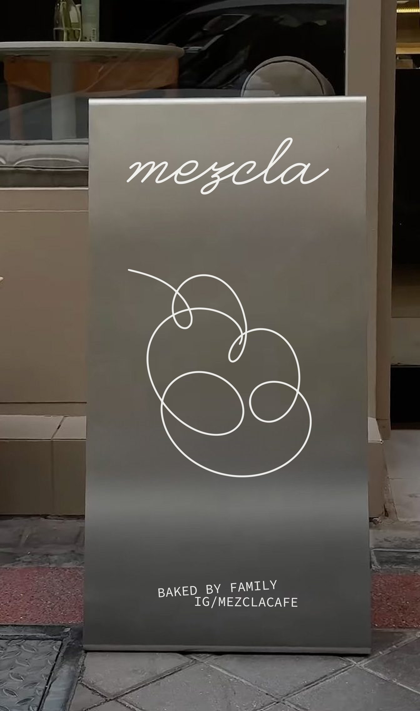 Atril de acero con el logo de Mezcla en vinilo blanco