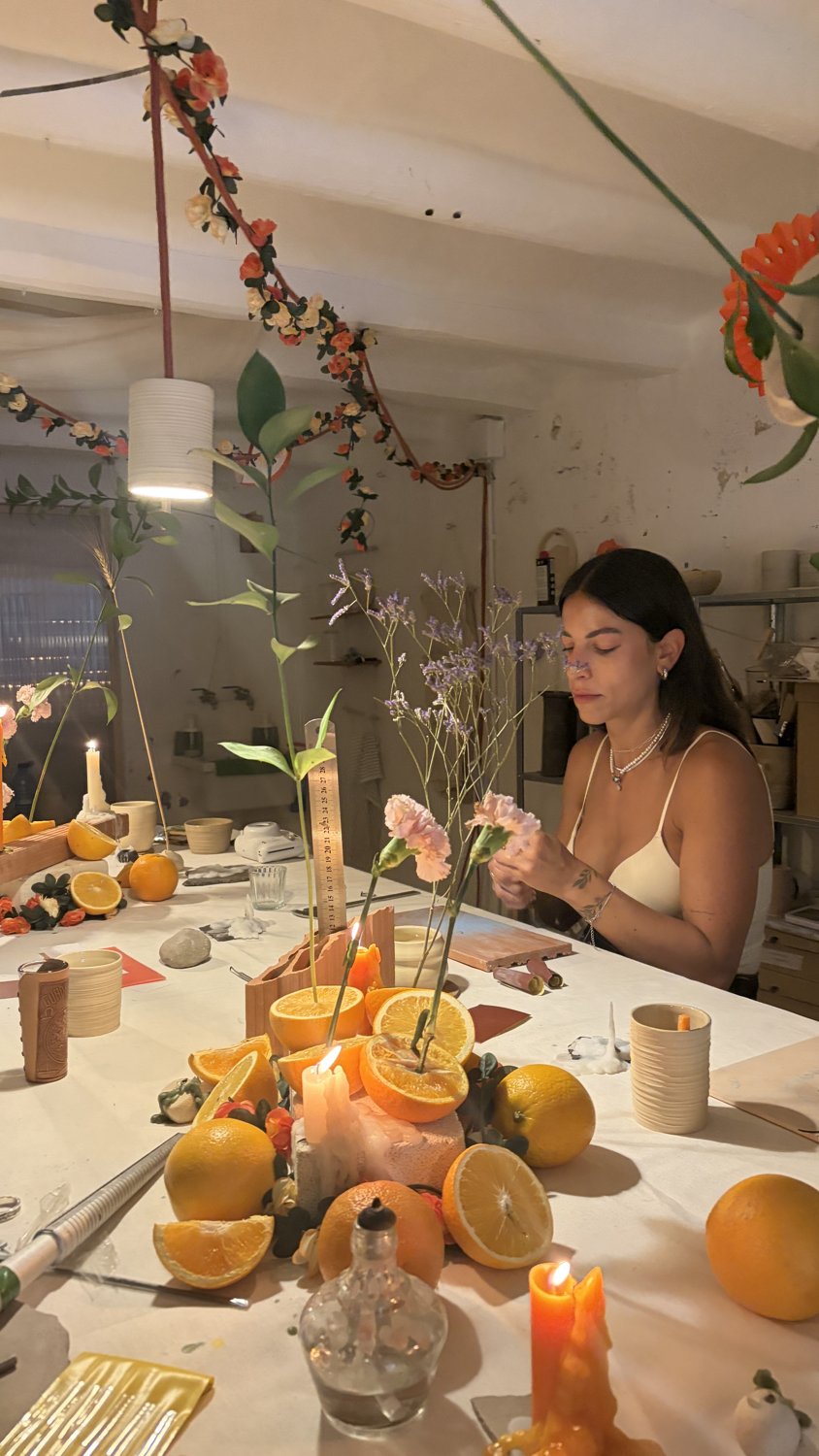 Mesa del taller con naranjas, velas y flores