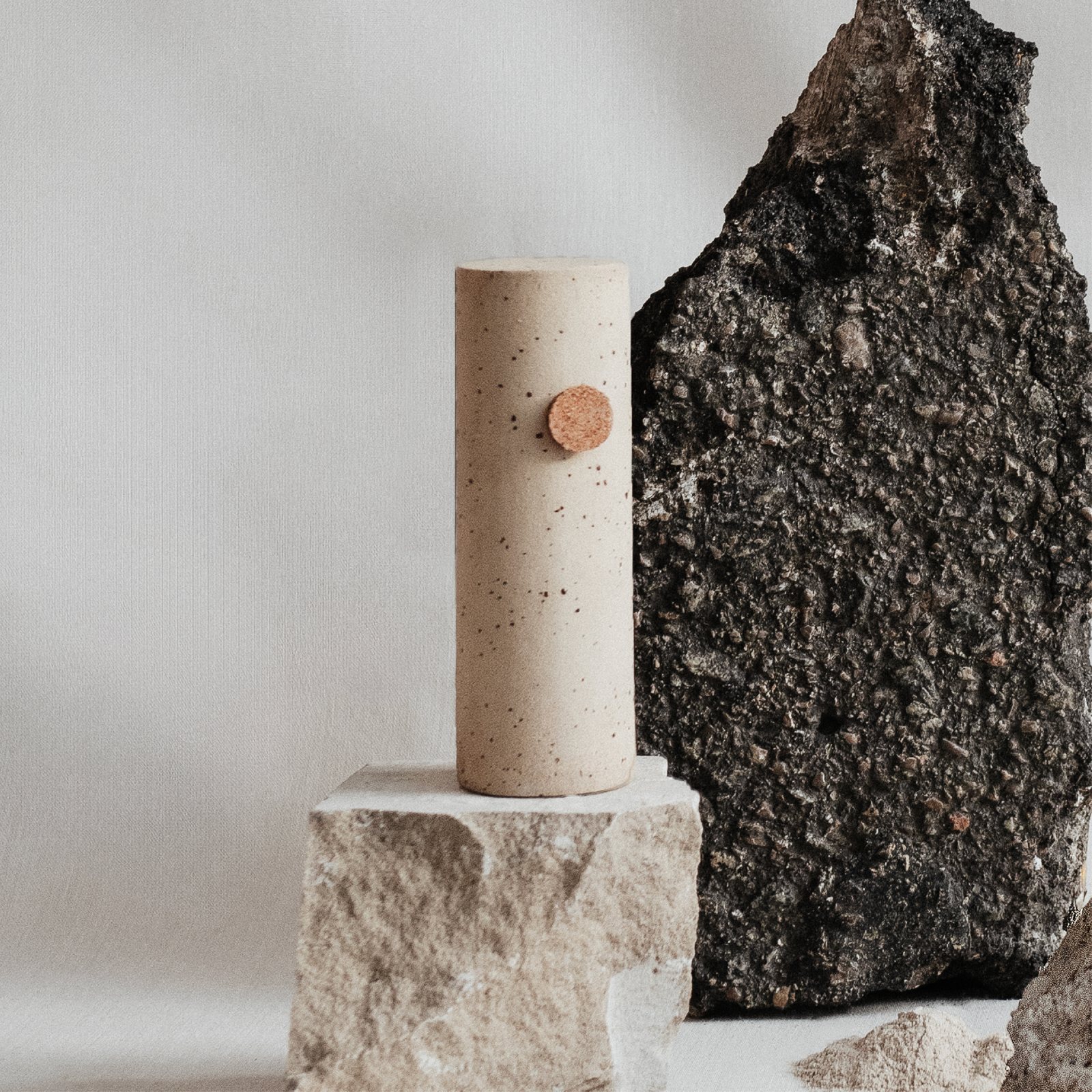Florero de cerámica moteada con tapón de corcho entre piedras