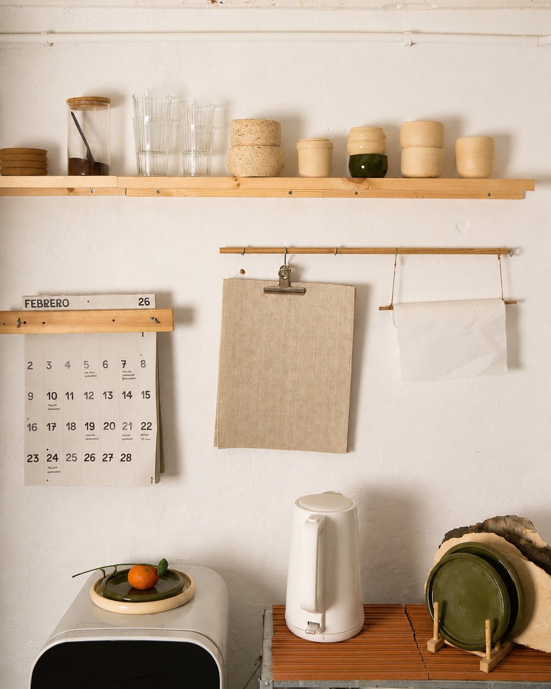 La cocina con estante, calendario y pava