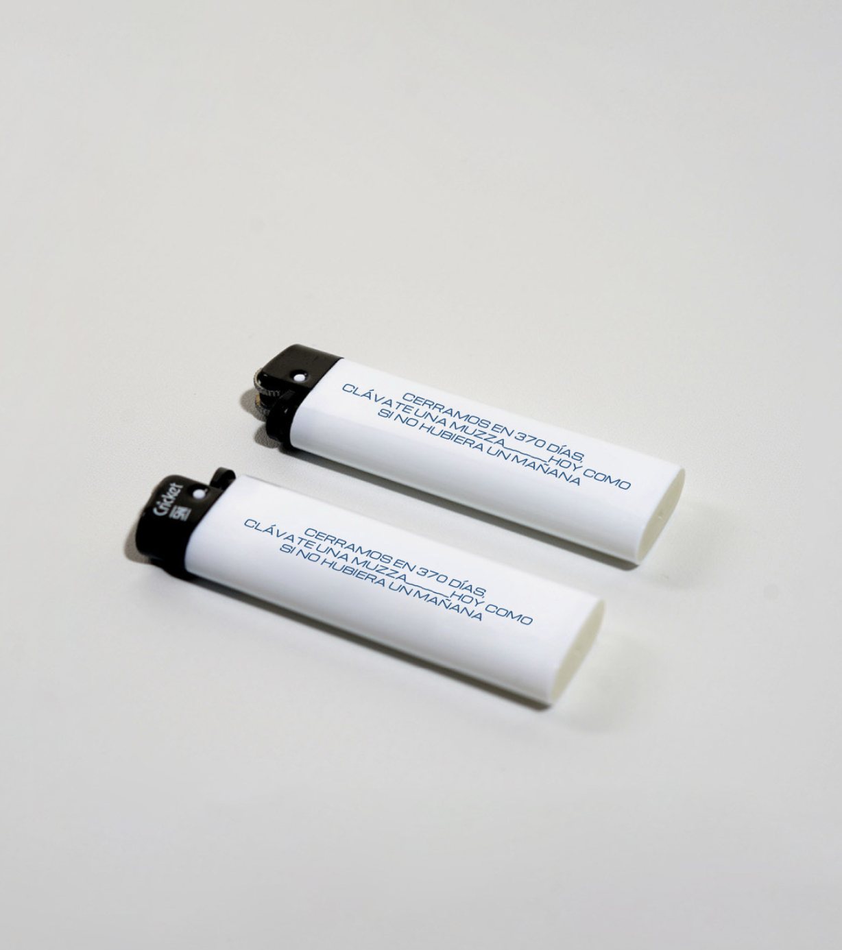 Encendedores blancos con frase de Muzza