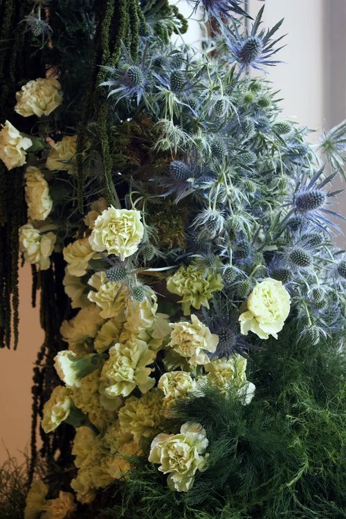 Detalle de claveles verdes, cardos azules y amaranto
