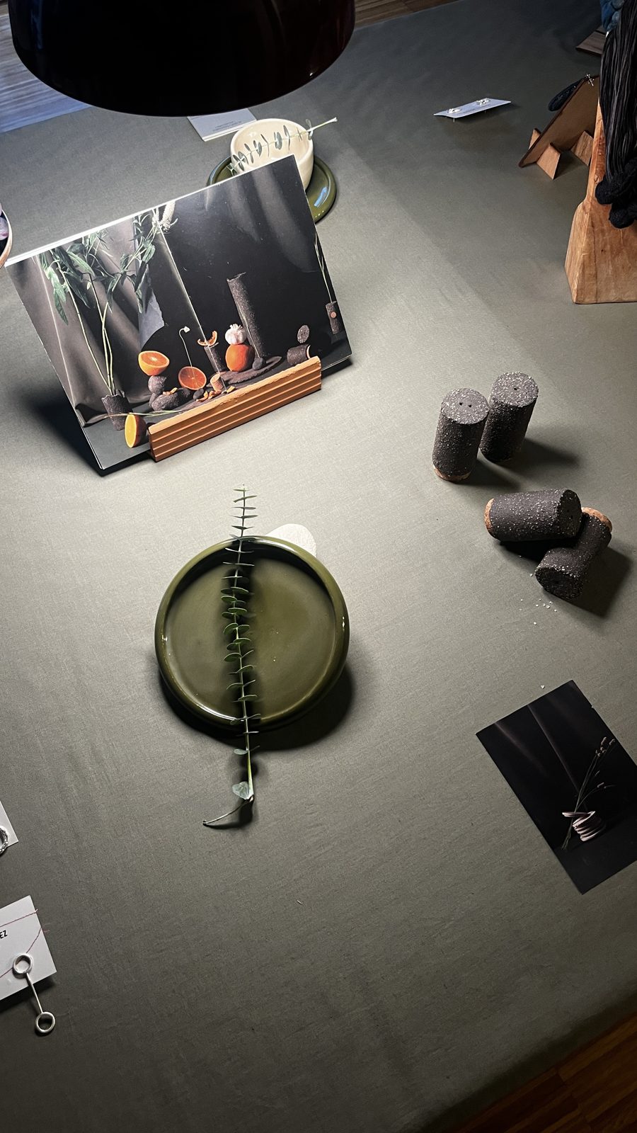 Mesa del pop-up con plato verde, cerámica y una foto de luces