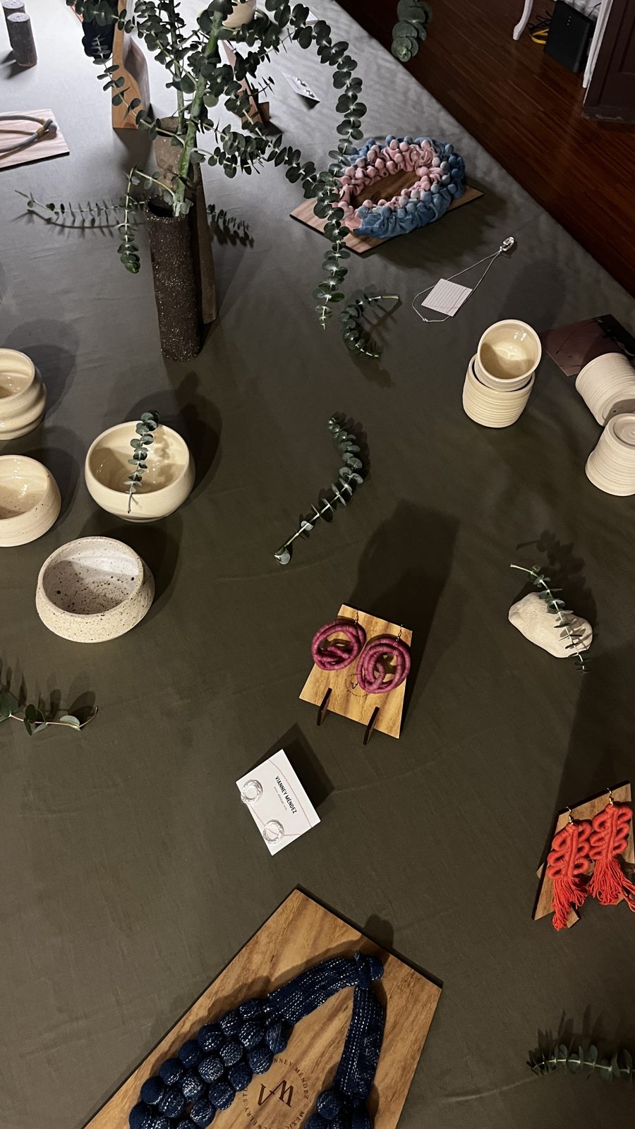 Mesa larga del pop-up con cerámica, joyas y ramas
